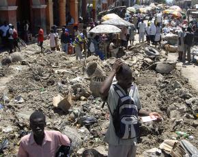 A busy street in Gonaïves, Haiti is strewn with wreckage after last year's hurricane season