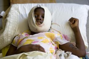 An injured girl rests in a hospital bed following the earthquake